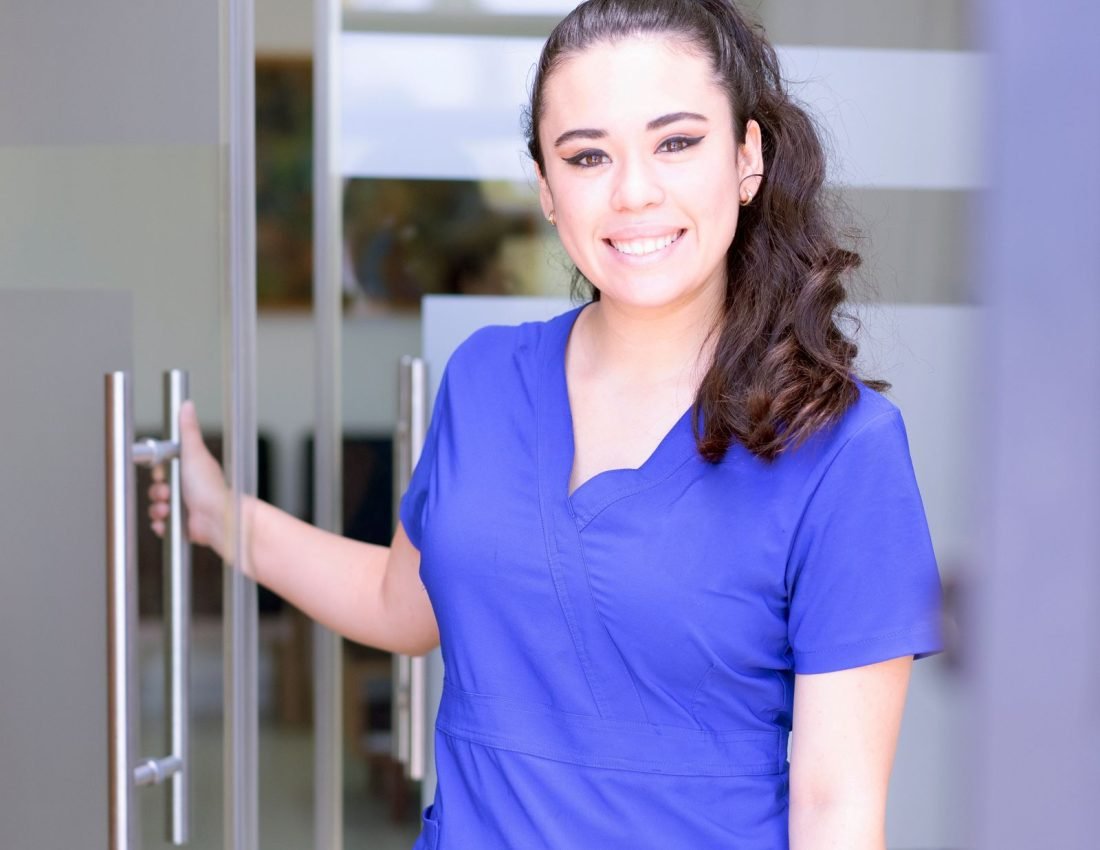 Smiling J&G Home Health Care caregiver in scrubs